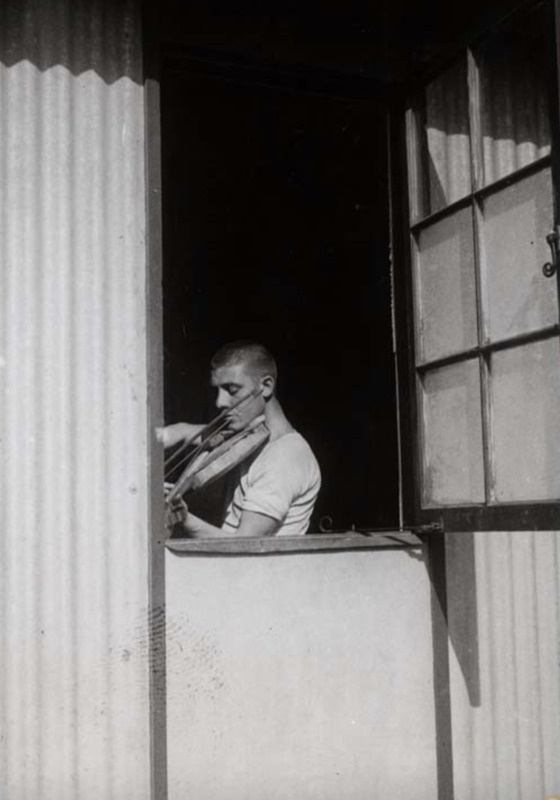 Zonderwater_8- 18 December 1942 - central hospital. A convalescent POW plays a hand-made violin.png