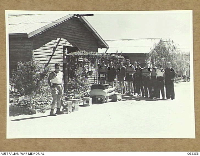 Prisoners of War in front of the huts of Hay Camp No. 7